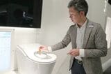 テスト機に模擬便を投入する川田氏。落下速度も便のタイプごとに忠実に再現される（写真：筆者撮影）