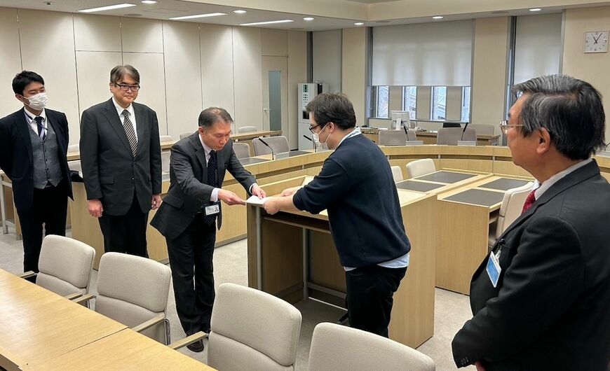 雇い止め撤回や更新上限の撤廃などを求める要望書とオンライン署名を、都教委の石毛朋充勤労課長（左）に手渡した。SCの1人は「今日は（大勢の）仲間のために、心理職の未来のためにここに来ました」と伝えた＝3月5日（筆者撮影）