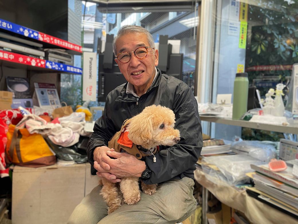 愛犬を膝に抱く関戸さん