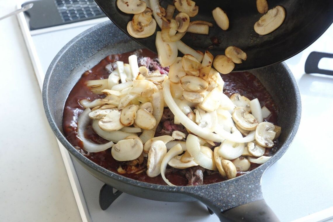 ソースにたまねぎとマッシュルームを投入