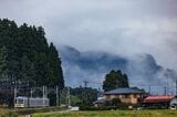 霧に包まれた日光の山々から抜けて電車がやってくる。行く先には日光連山が迫る（撮影：鼠入昌史）