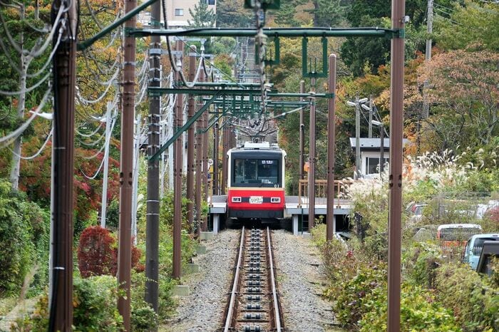 山上からワイヤーロープに引っ張られて上っていく