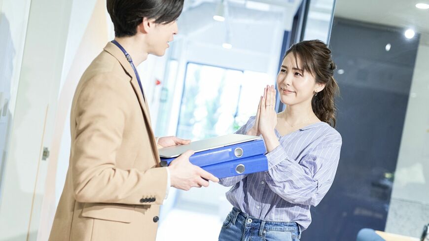 申し訳なさそうな表情で仕事を頼む女性