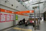 地下2階直通のエスカレーター。オレンジ色の案内サイン（記者撮影）