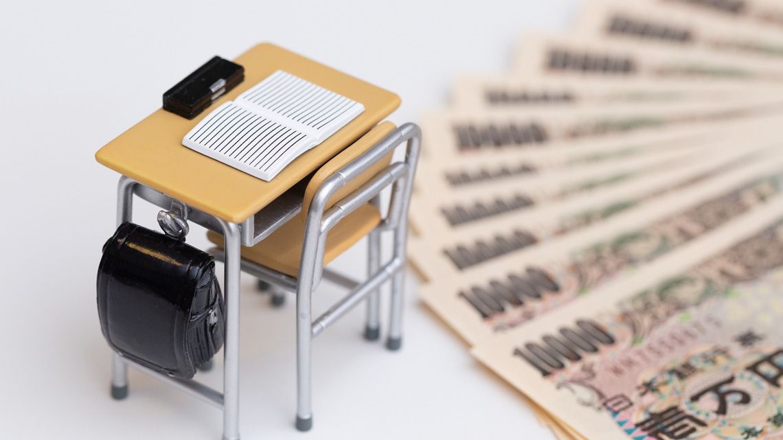 学校の机のミニチュアと一万円札