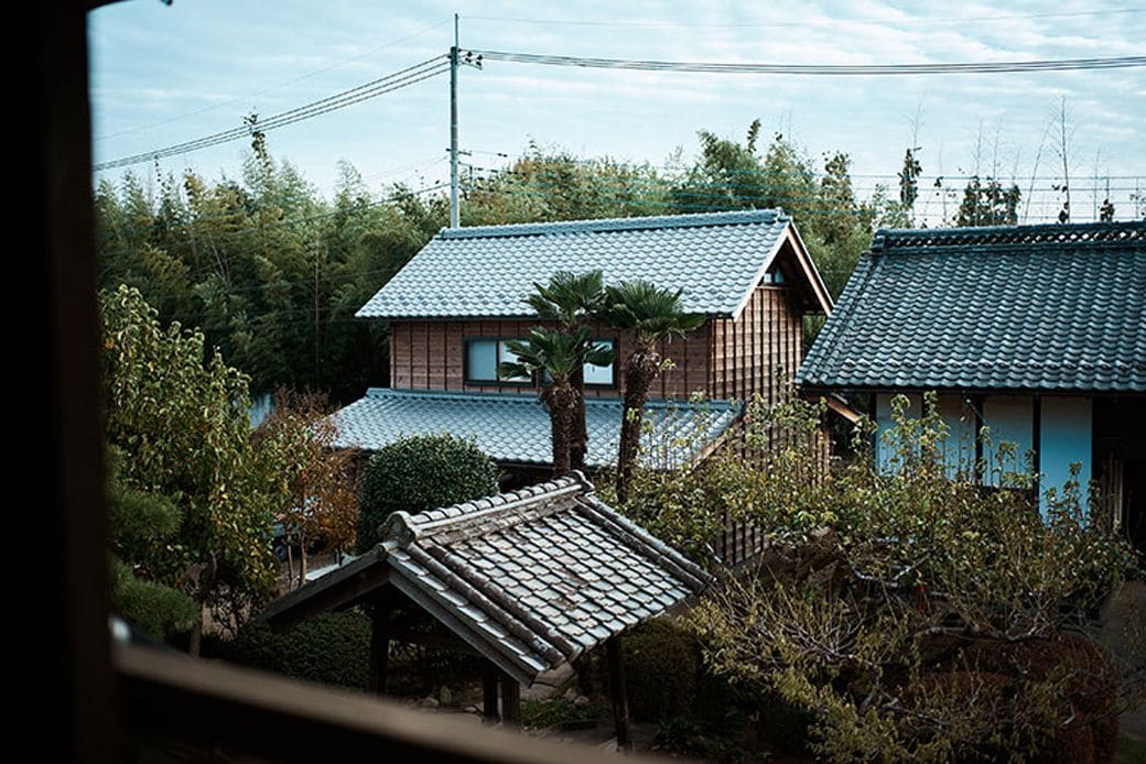 奥に見える2階建ては、傾きかけた蔵を解体し、軸組を再利用して建てた農作業のための建物。1階では収穫した野菜の梱包作業、2階では打ち合わせができる（写真撮影／相馬ミナ）