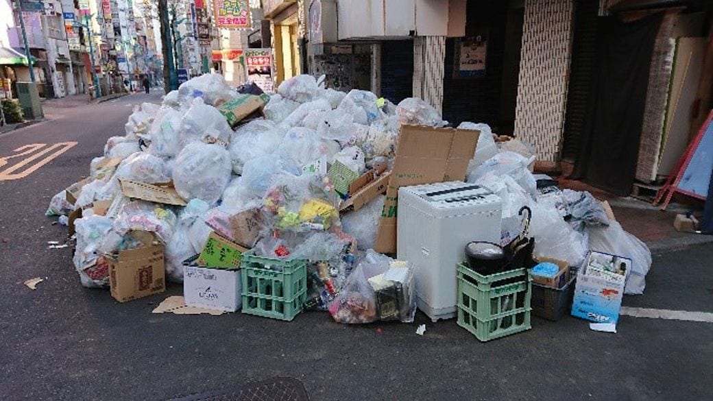 過去には、正月明けの歩道にごみが積まれていた。洗濯機も不法投棄されている（筆者撮影）