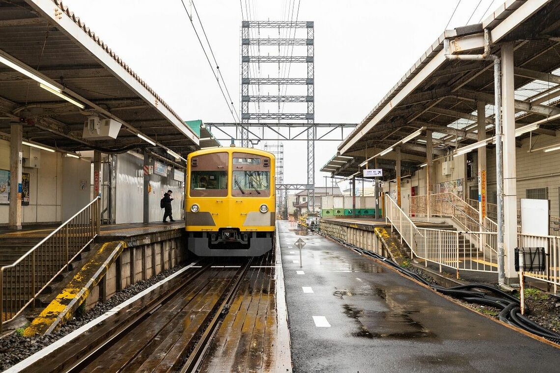 多磨駅の構内踏切から是政方面を見る。線路上に東京電力の電線が通る（筆者撮影）