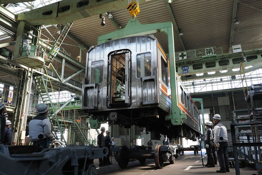 クレーンで車体を吊り上げて台車上に下ろす「架台下ろし」（撮影：伊原薫）