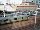 川口駅に停車する京浜東北線（奥）と通過する上野東京ラインの列車（記者撮影）