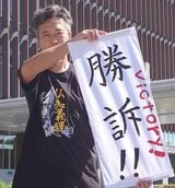 勝訴判決の旗出しをするヤブキレン氏（出所：LIA）