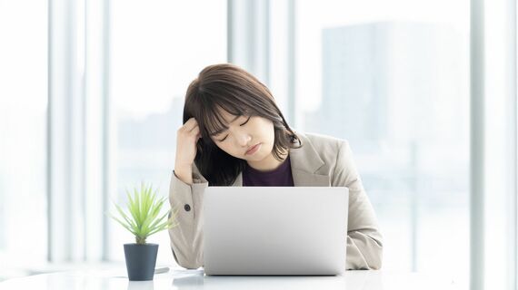 パソコンを使いながら悩む人物