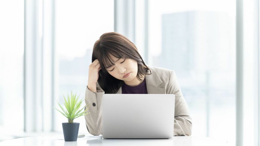 パソコンを使いながら悩む人物