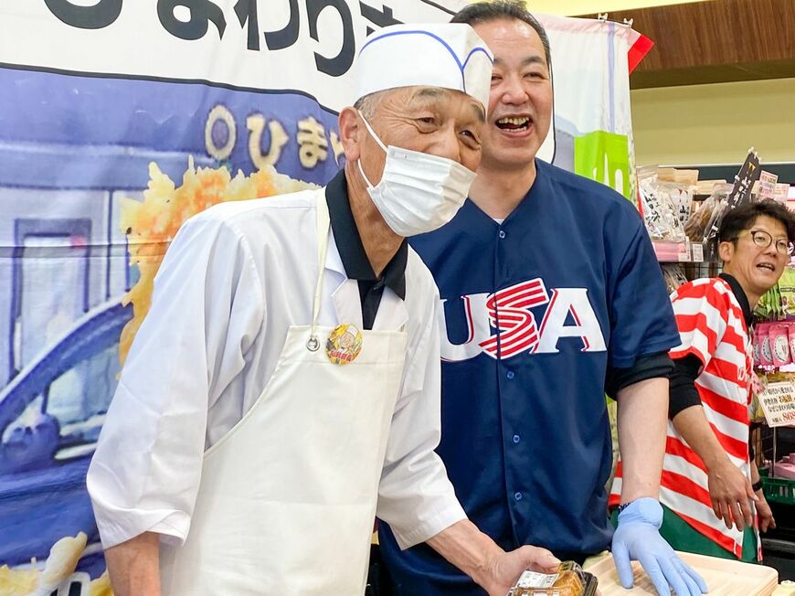 行列に並ぶお客さんに笑顔を見せる修仁郎料理長（左）、ポール中山さん（左から2番目）と副店長・ウォーリーさん（左から3番目）（写真：ひまわり市場提供）