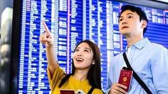 空港でフライト確認するカップル