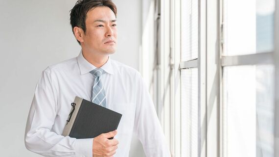 窓の外を眺める教員