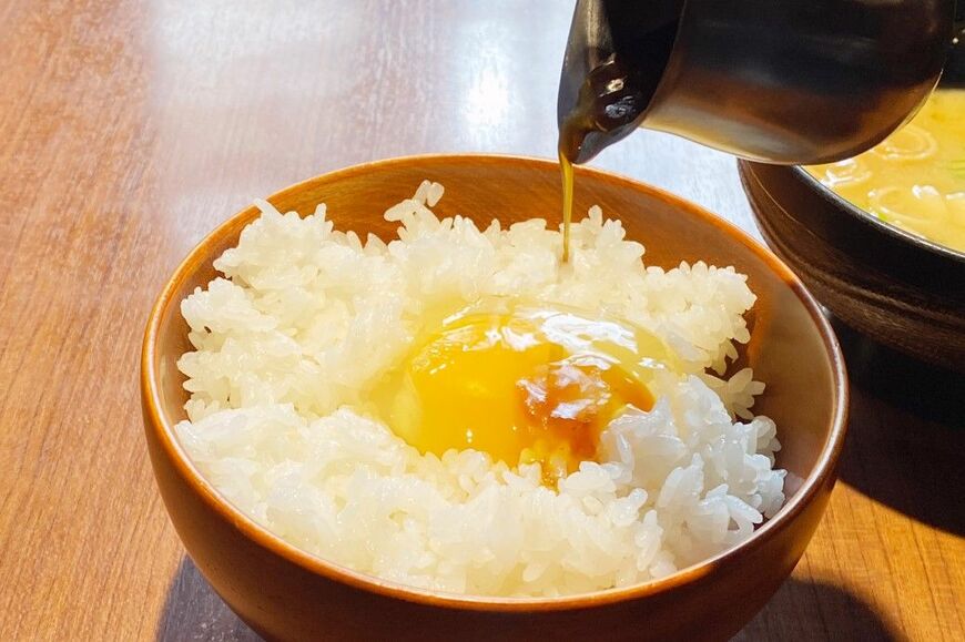 ピッチャーに入ったオリジナルソースを生卵にかけて、いただきます（著者撮影）