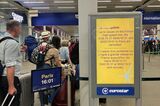 イギリスとフランス方面を結ぶ「ユーロスター」が発着するロンドン・セントパンクラス駅。運休便を告知する案内板と、数少ない列車に乗る人々の列＝7月26日（筆者撮影）