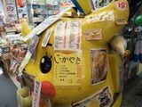巨大なピカチュウの人形を覆い尽くすように貼られた喫茶室のメニュー（筆者撮影）