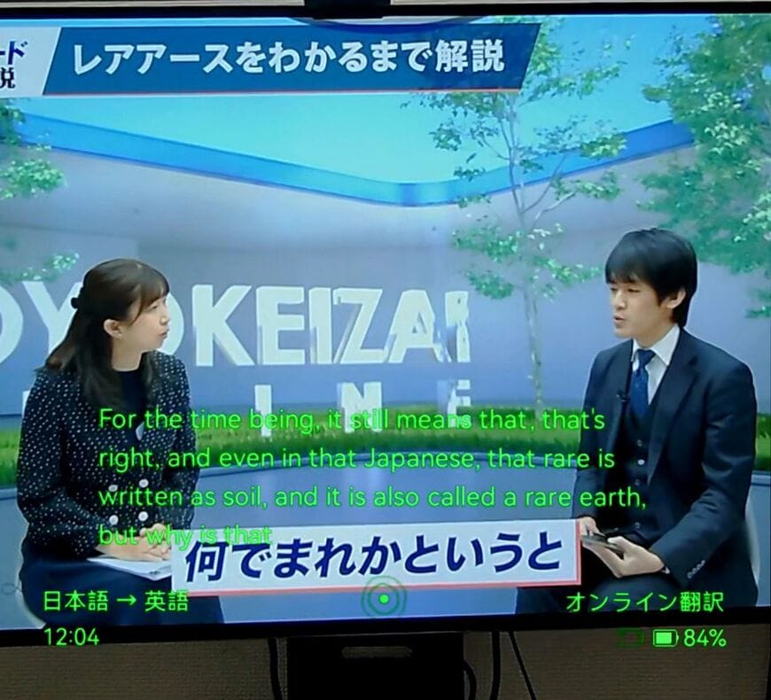 デモ機能を使い、見ている風景とRokid AIグラスの画面を合成したもの。このように、翻訳中の文字が目の前に見える（写真：筆者撮影）