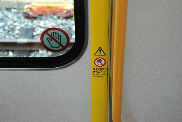 ドア開閉時の引き込み注意を示すサイン