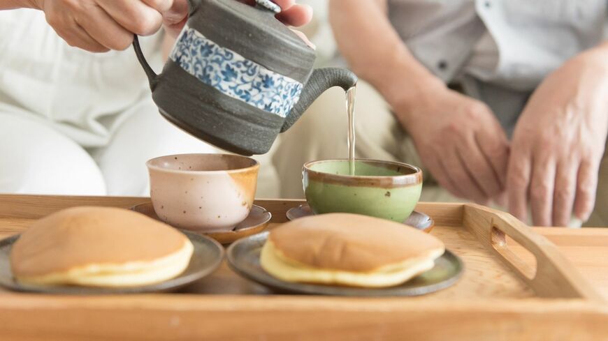 お茶とどら焼きを準備するシニア夫婦