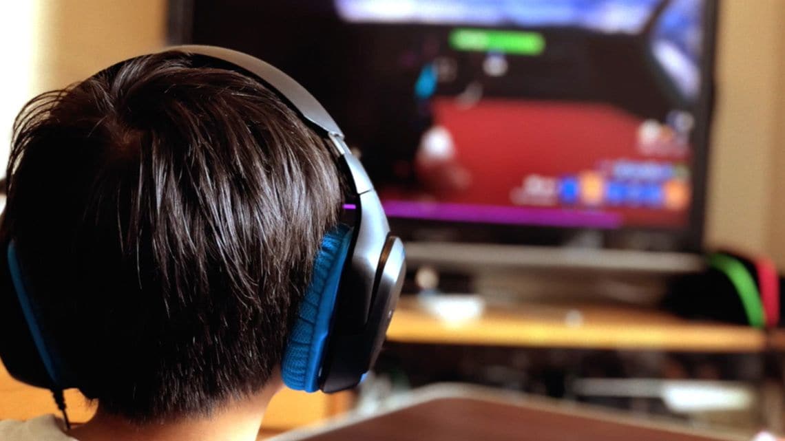 ヘッドセットを装着してビデオゲームをする子ども