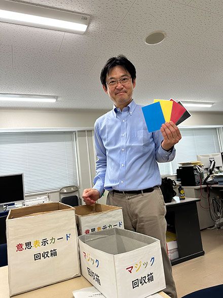 授業への主体的な参加を促す仕掛けを説明する岡田氏。学生はカード型のリアクションペーパーを使って意思表示をする（写真：筆者撮影）
