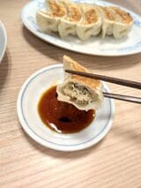 タレを付けて焼餃子を食べる様子