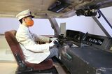 ロマンスカーの運転室を再現した運転シミュレーターに座る現役運転士（撮影：尾形文繁）