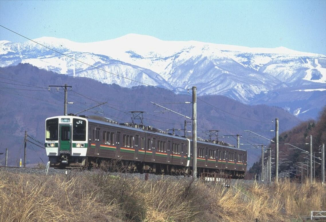 蔵王連峰と719系5000番台の普通列車