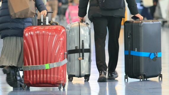 スーツケースをもって空港を歩く人たち