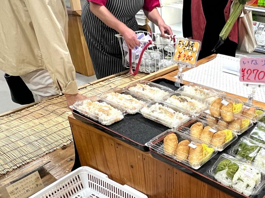 草だんご補充の様子。スタッフがかごに入れた草だんごを持ってくると、あたりにいた客がすぐに集まる（筆者撮影）