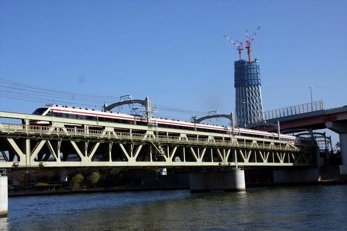 建設中の東京スカイツリーをバックに走る「りょうもう」