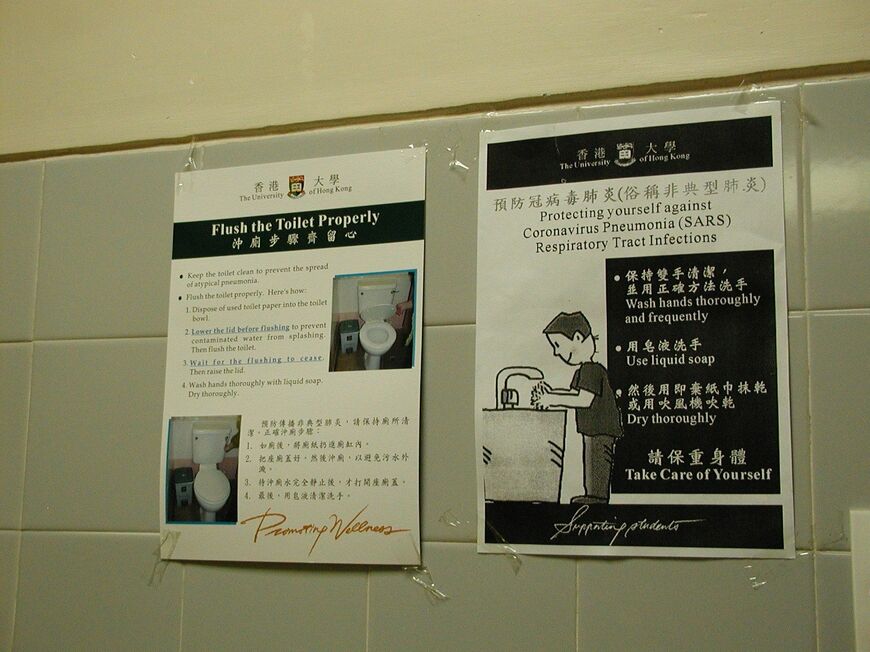 2003年当時、香港では、中国語と英語でトイレを流すときにはふたをした状態でするように指示するポスター（筆者撮影）
