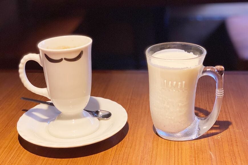 左がホットコーヒー、右がヨーデル。プレーンヨーグルトと飲むヨーグルトと中間程度の、とろりとした食感はまるで飲む食べ物。しっかりとしたヨーグルトのうまみと、優しい甘みは、癖になるおいしさ（筆者撮影）