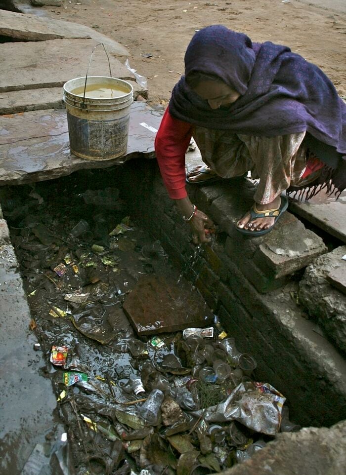 ドブに漏れ出す水道水も住民はすくって使う。