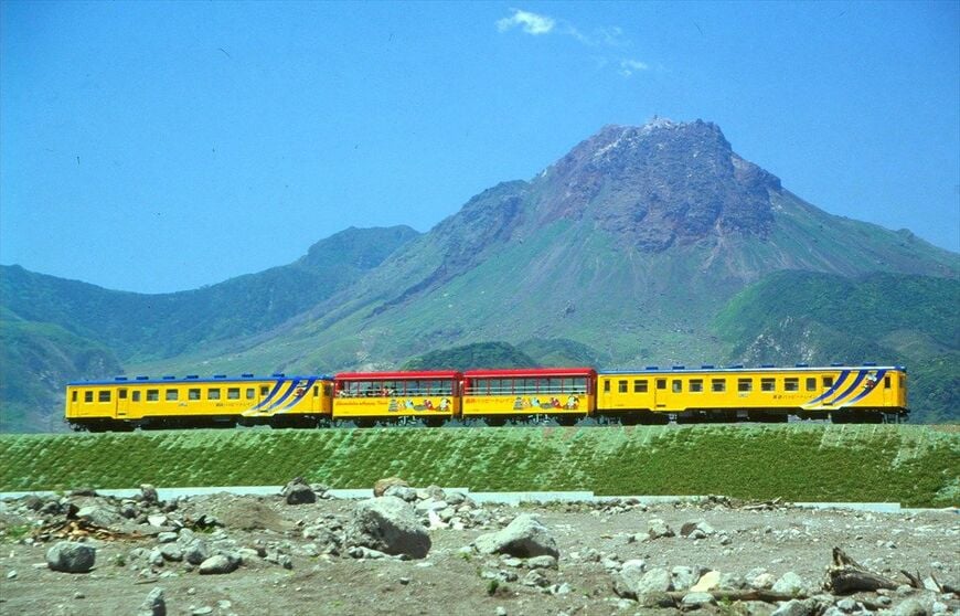 普賢岳を背景に走る島原鉄道のキハ20形トロッコ列車（撮影：南正時）