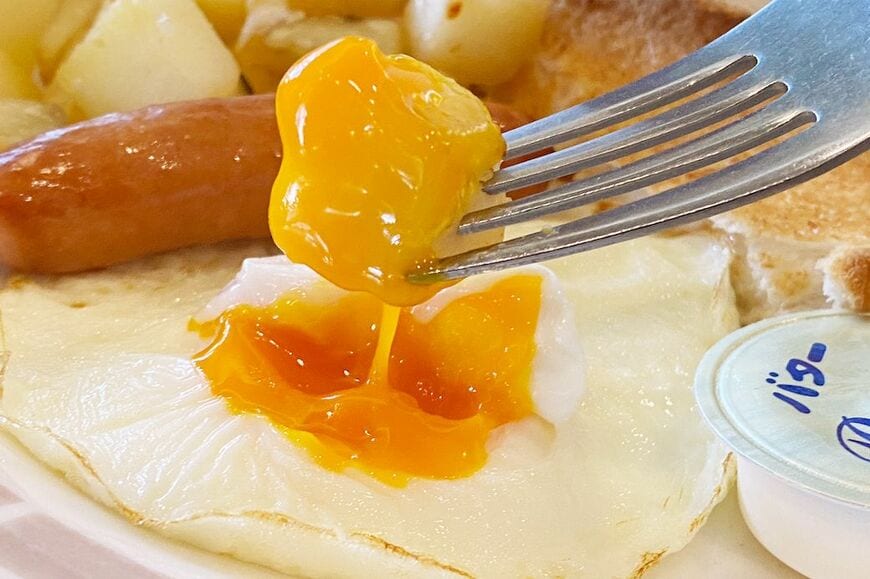 目玉焼きの黄身は絶妙な半熟具合。ポテトにからめていただきます（筆者撮影）