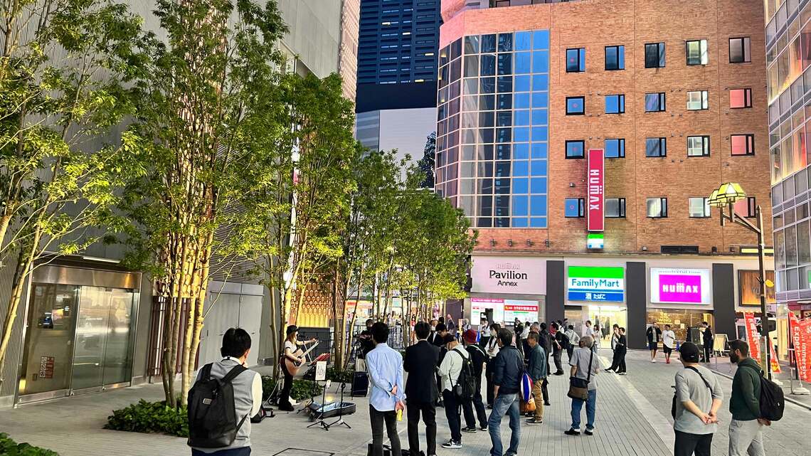 タワー横ではじまった路上ライブに人々が足を止め歌に聞き入っていた（写真：松原大輔）