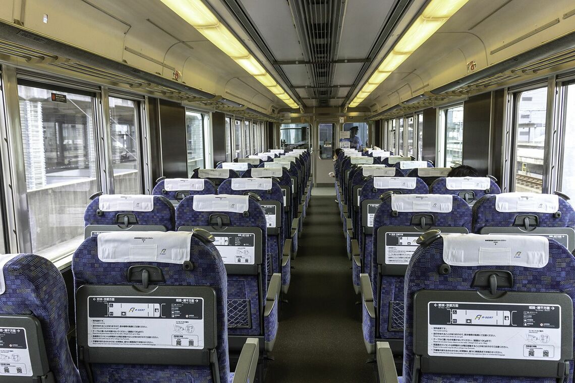 車内は塞いだ中央ドア部分も含めて特急普通車と同じリクライニングシートがずらりと並び片方は12列、もう一方には11列（写真：久保田 敦）
