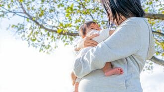 子どもを抱っこする妊婦