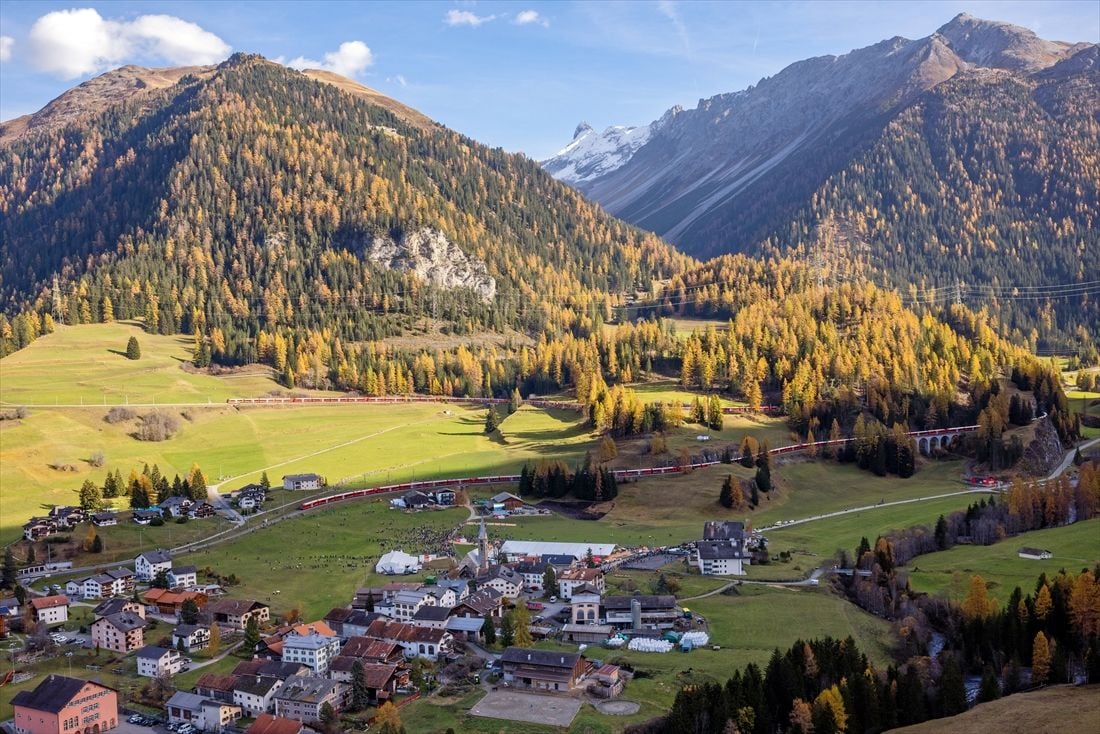 麓の集落を駆け抜ける。住民が集まっているのが見える（写真：PHILIPP SCHMIDLI／RhB）