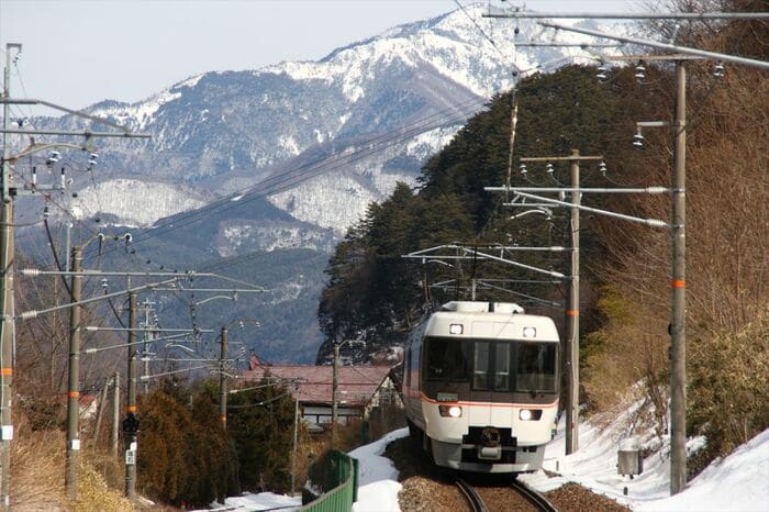 雪景色の木曽福島付近を走る383系「しなの」