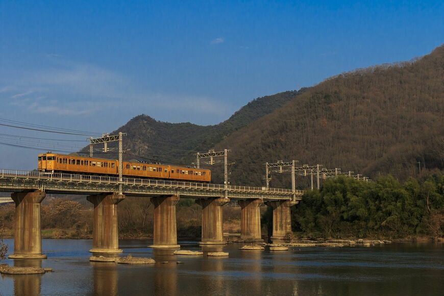 吉井川を渡る山陽本線。115系は瀬戸内の青空に映える（撮影：鼠入昌史）
