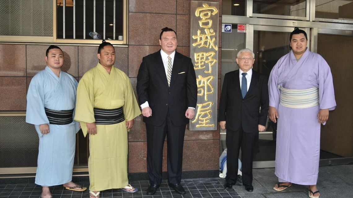 部屋の前で記念撮影に応じる宮城野親方（左から3人目）。左から炎鵬、石浦、1人おいて先代宮城野親方の間垣親方、北青鵬（2022年8月20日撮影）