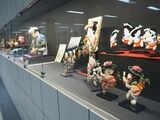 通路壁面に展示された博多人形などの伝統工芸品（記者撮影）