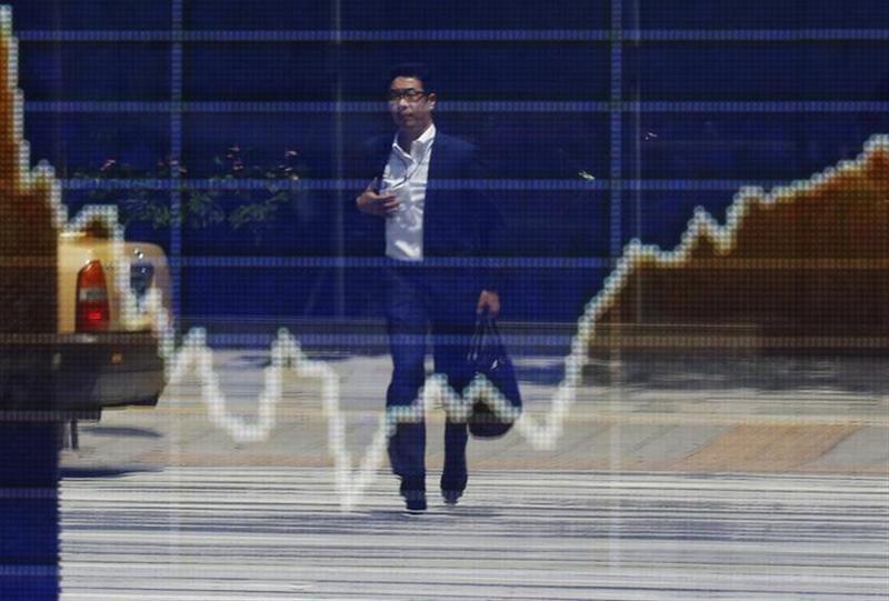 １１月２５日、東京株式市場で日経平均は３日続伸。高値引けとなり、約半年ぶりに終値ベースで１万５６００円台を回復した。写真は都内の株価ボード。８月撮影（２０１３年　ロイター/Toru Hanai）
