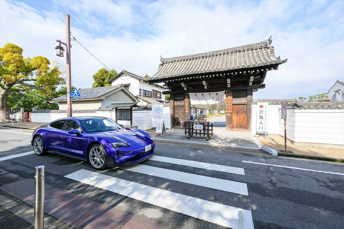 会場入口の前を走る試乗車両のポルシェ「タイカン」（写真：JAIA）
