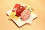 100店舗記念の限定メニュー、「紅白まぐろ合戦」（759円）（4月22日で販売終了）。希少な天然インドマグロの赤身、本鮪の大とろの2種盛り。卵黄醤油にくぐらせた厚切りの赤身は濃厚さと脂の甘み、さっくりとした口当たりが食べ応え十分。炙った大とろもとろける舌触りだ（撮影：尾形文繁）